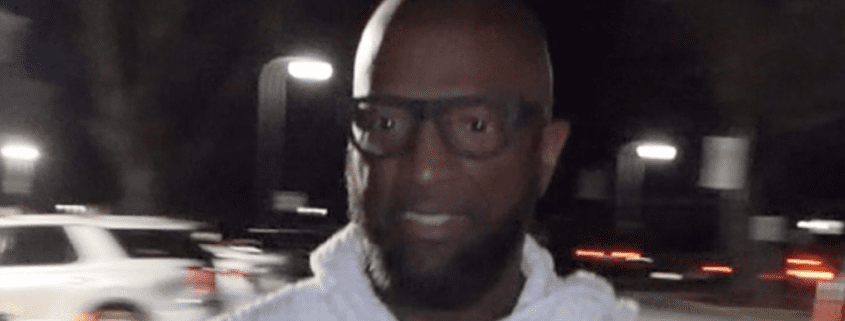 Man wearing glasses at night, blurred background.